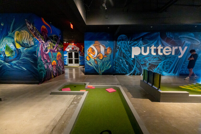 Dive into an underwater adventure with the deep sea-themed street art decor at Drive Shack's Puttery mini golf course.