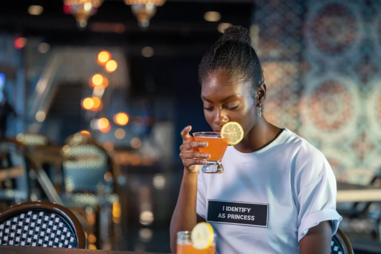 Guest enjoying a citrus-garnished craft cocktail inside Drive Shack.