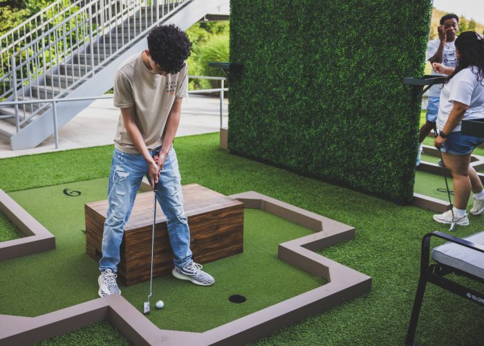 Immerse yourself in an artistic oasis at Drive Shack, featuring Puttery's outdoor art garden mini golf course.